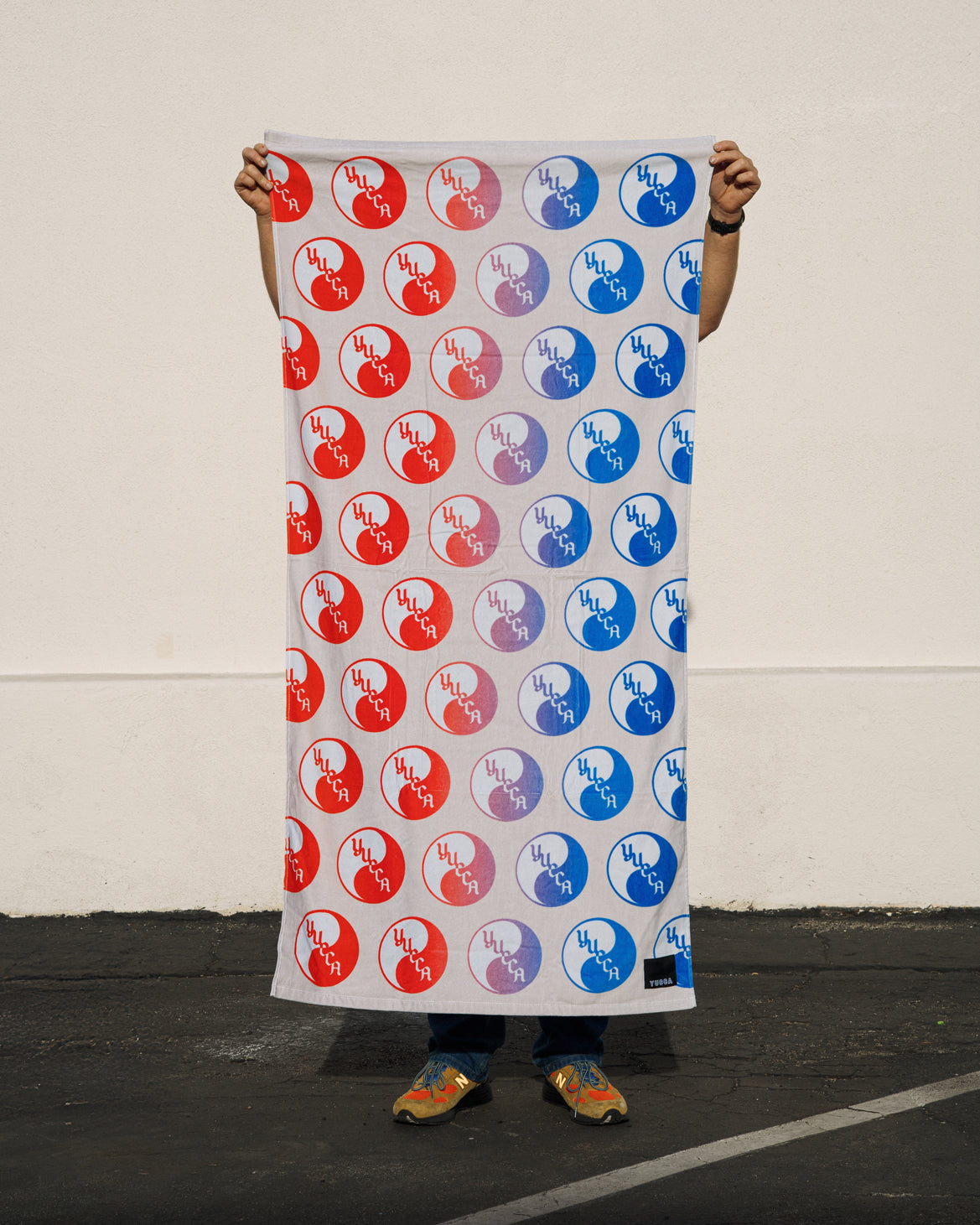 Man holding up Yucca Yin Yang Beach Towel